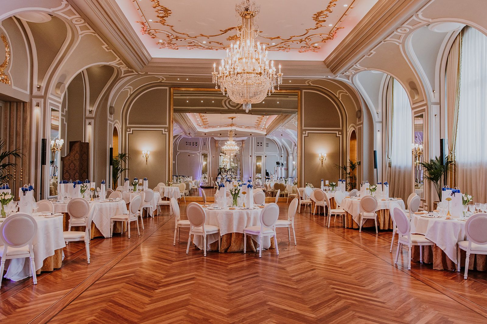 Salón de banquete con mesas redondas y lámpara de araña